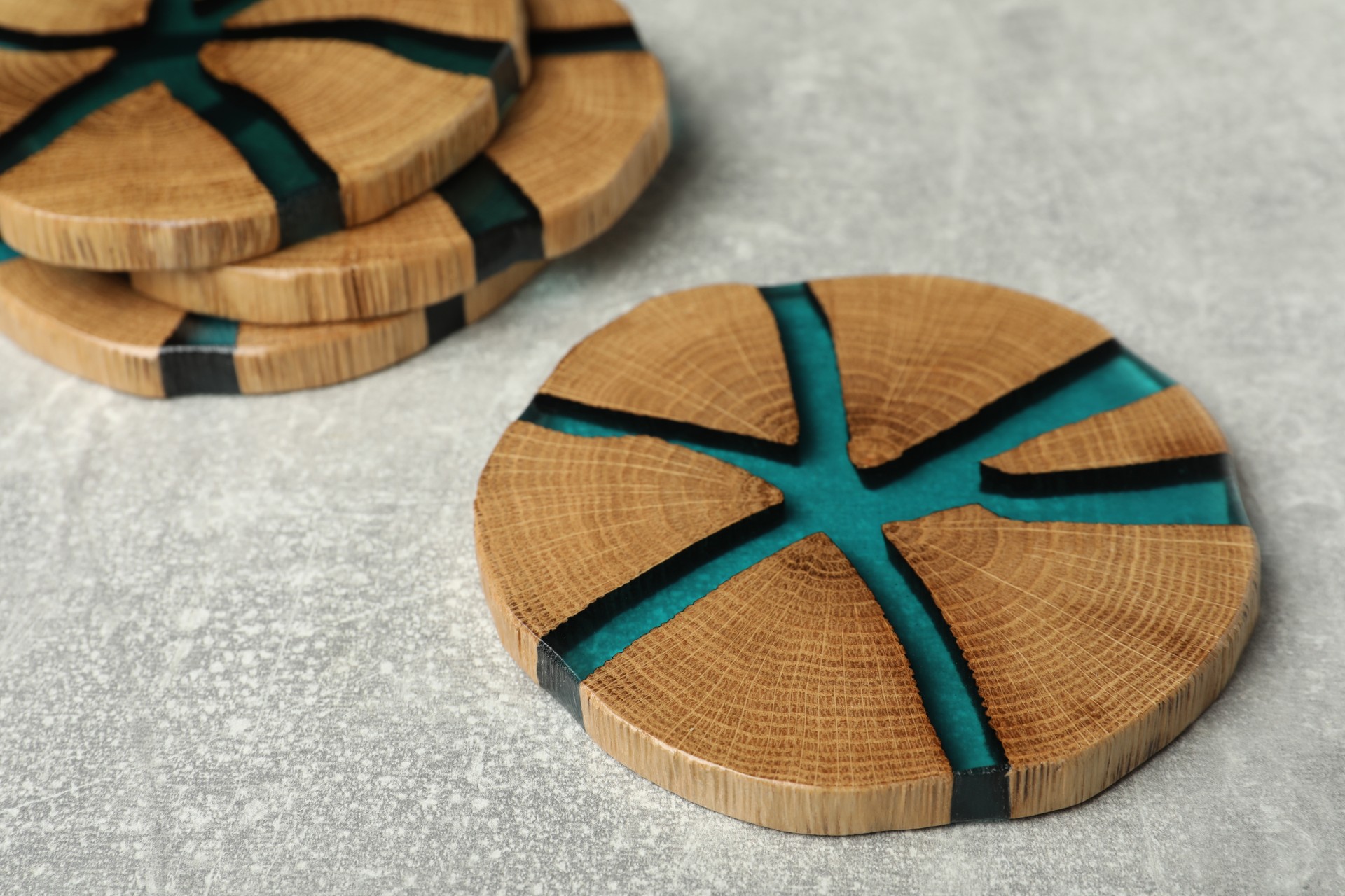 Stylish wooden cup coasters on light grey table