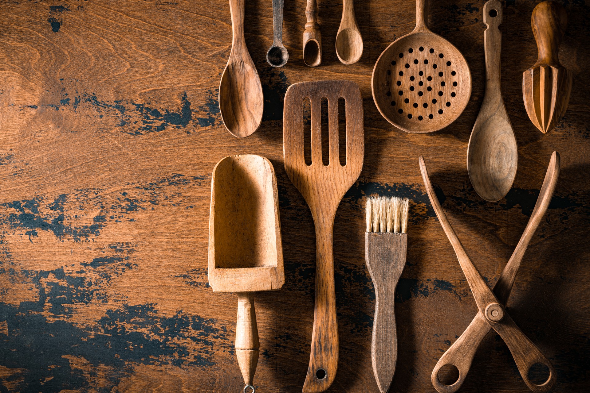 Wooden cutlery and kitchenware arrangement on rustic wood table board